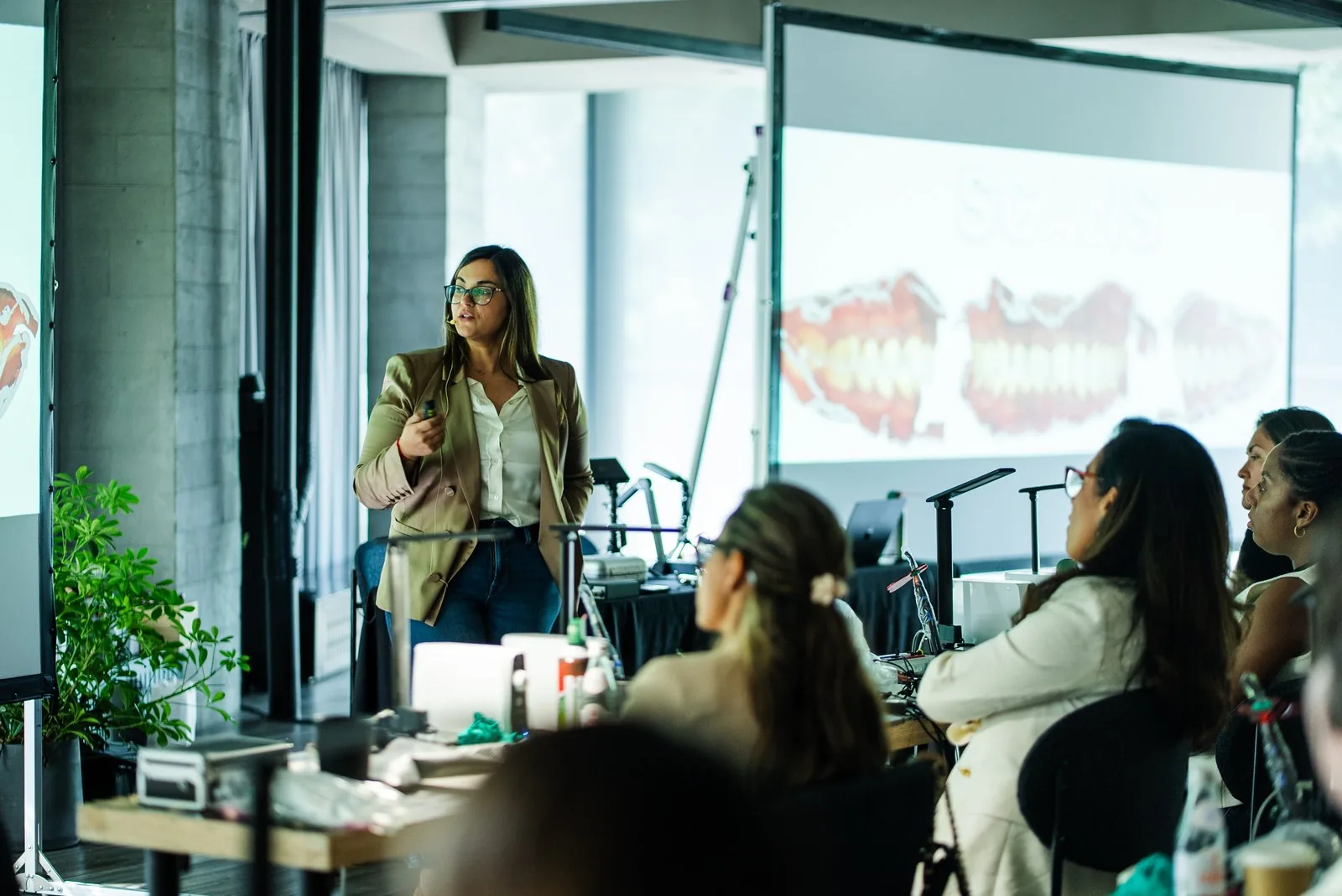 Dr. Andi-Jean Miro presents close-up dental model images to dentists at Art of Ceramic