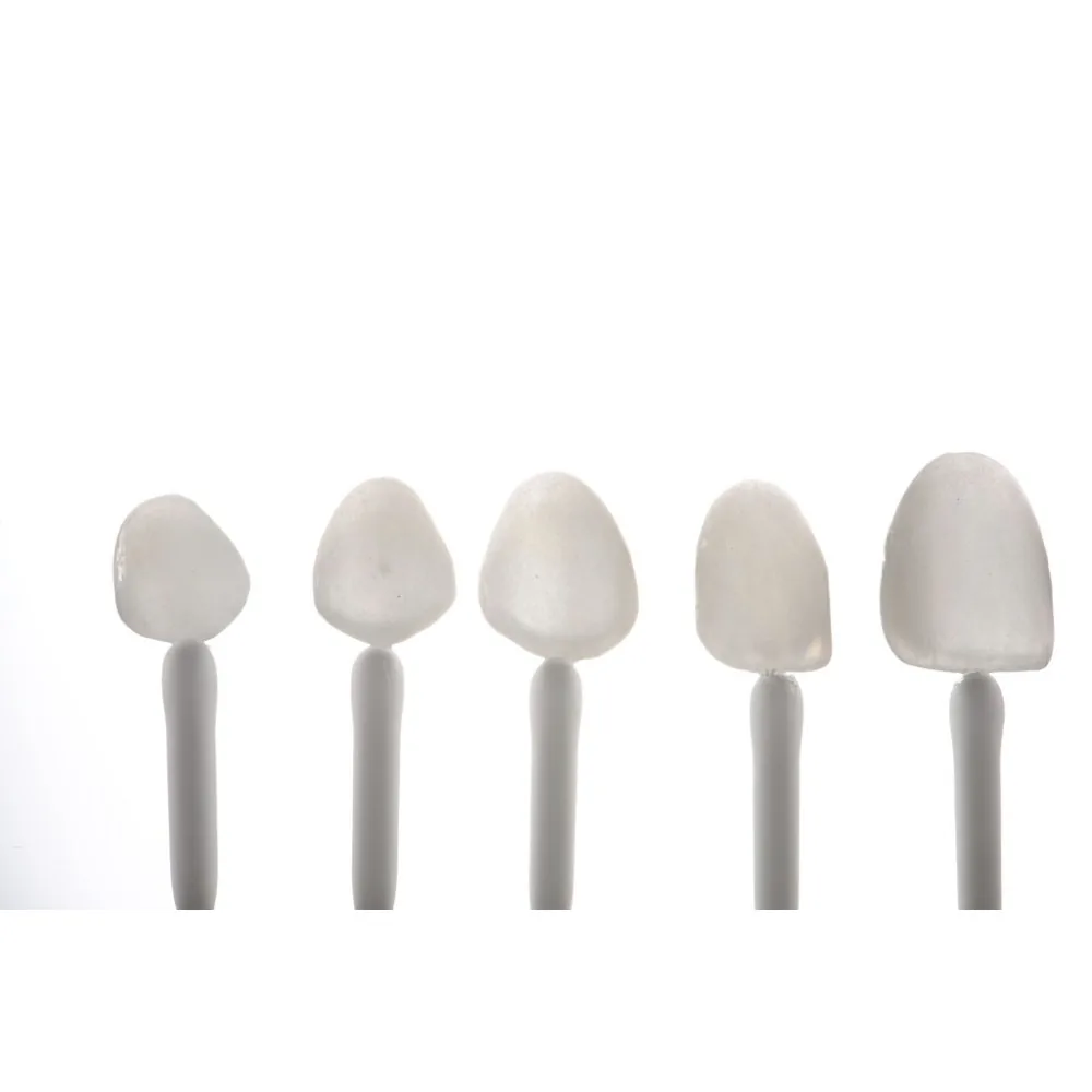 A single porcelain veneer sample on a stick, photographed on a neutral background