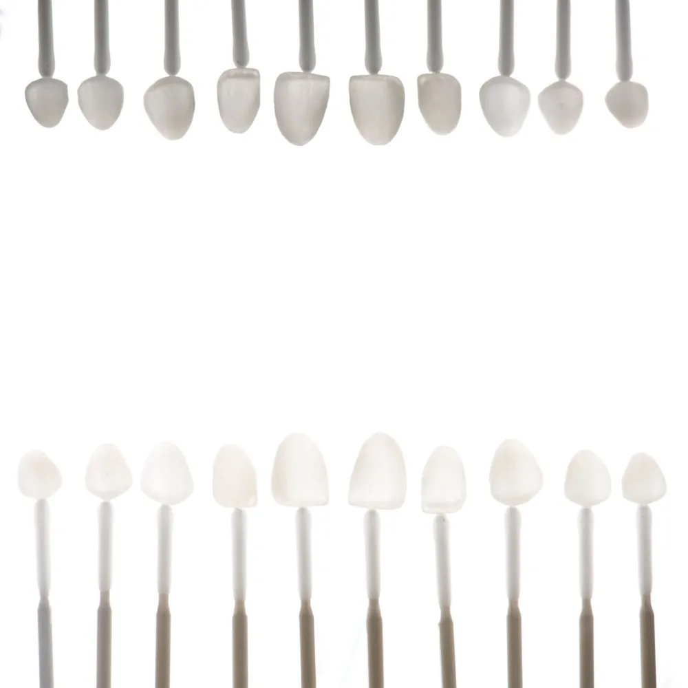 A row of porcelain veneer samples on sticks in graduated shades