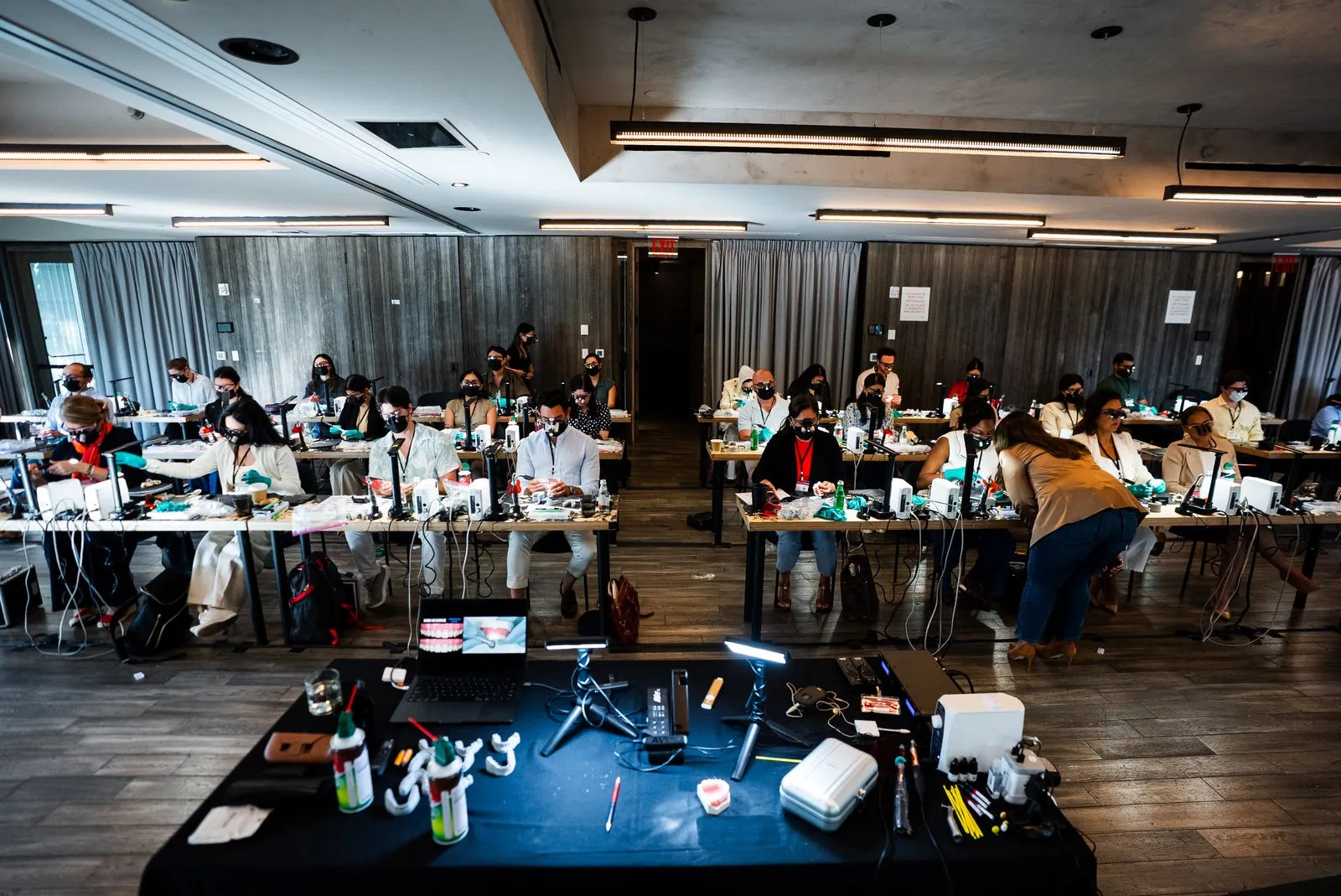 Dentists working at their benches with models and loupes during an Art of Ceramic veneer course